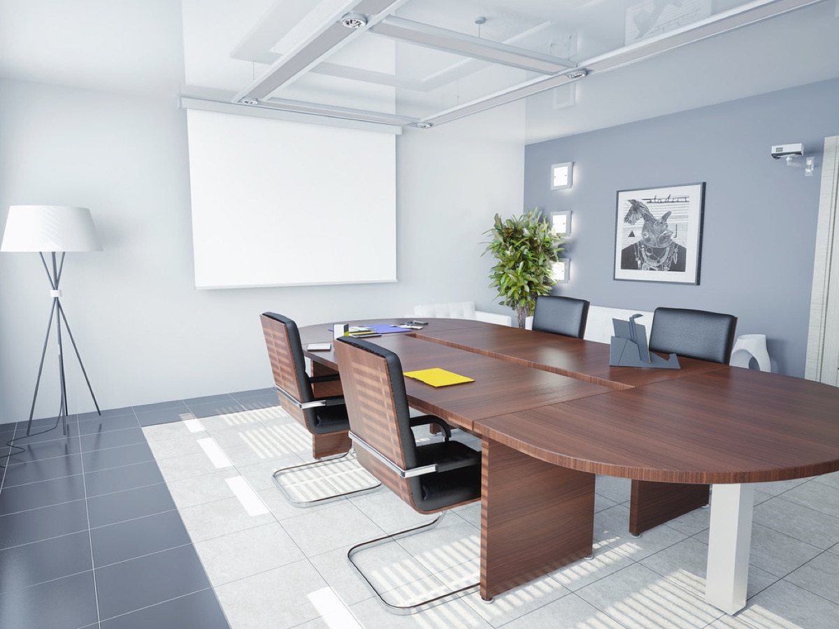 A bright, empty office meeting room with a long wooden table